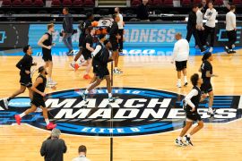 The Providence men's basketball team warm up over the March Madness logo during practice for the NCAA men's college basketball tournament in March 2022.