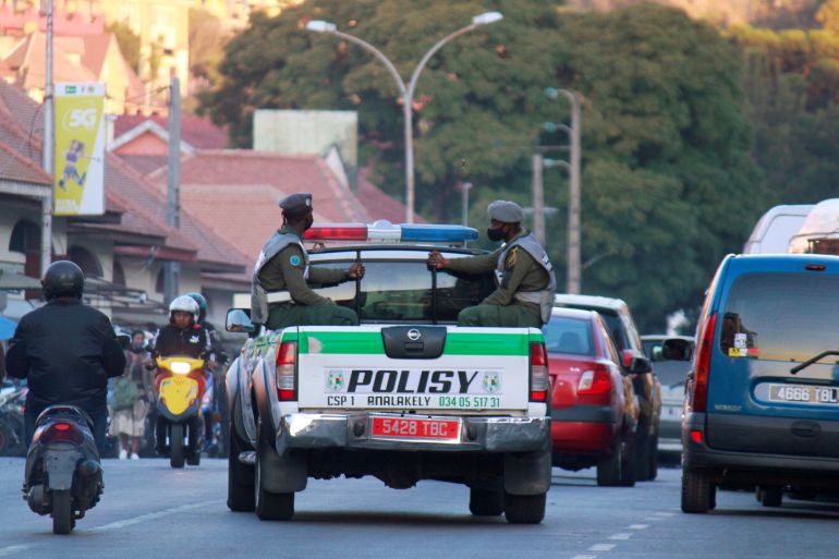 Police officers ride on their pickup truck as they patrol in downtown Antananarivo