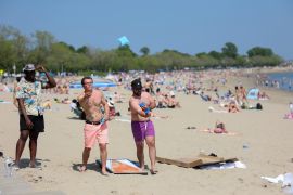 People on a beach in Boston, Massachusetts, US, on May 22, 2022