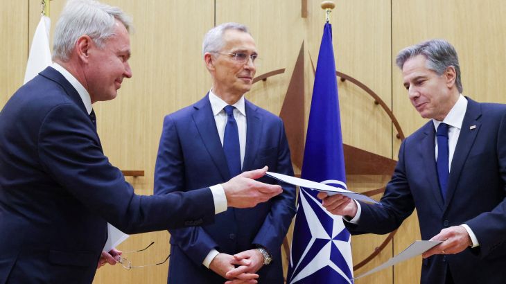 Finnish Foreign Minister Pekka Haavisto hands over his nation's accession document to U.S. Secretary of State Antony Blinken as NATO Secretary-General Jens Stoltenberg stands during a joining ceremony at the NATO foreign ministers' meeting at the Alliance's headquarters in Brussels, Belgium April 4, 2023. REUTERS/Johanna Geron/Pool