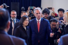 Taiwan President Tsai Ing-wen stands next to House Speaker Kevin McCarthy, as people raise cameras and phones to photograph the visit