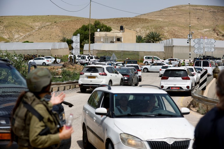 Israeli troops stand guard at a shooting attack scene in the Jordan Valley in the Israeli-occupied West Bank