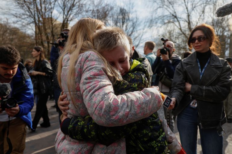 Ukrainian woman embraces her 13-year-old son