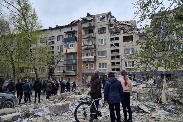Local residents stand next to an apartment building damaged by a Russian military strike, amid Russia's attack on Ukraine, in Sloviansk, Donetsk region, Ukraine April 14, 2023. Press service of the Donetsk Regional Military-Civil Administration/Handout via REUTERS ATTENTION EDITORS - THIS IMAGE HAS BEEN SUPPLIED BY A THIRD PARTY. MANDATORY CREDIT. DO NOT OBSCURE LOGO. NO RESALES. NO ARCHIVE.