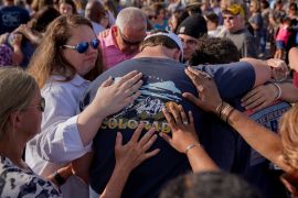 Community members embrace each other during a vigil in Dadeville