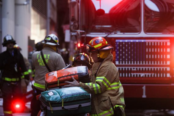 Firefighters check their equipment at the site of a collapsed parking garage in the Manhattan borough