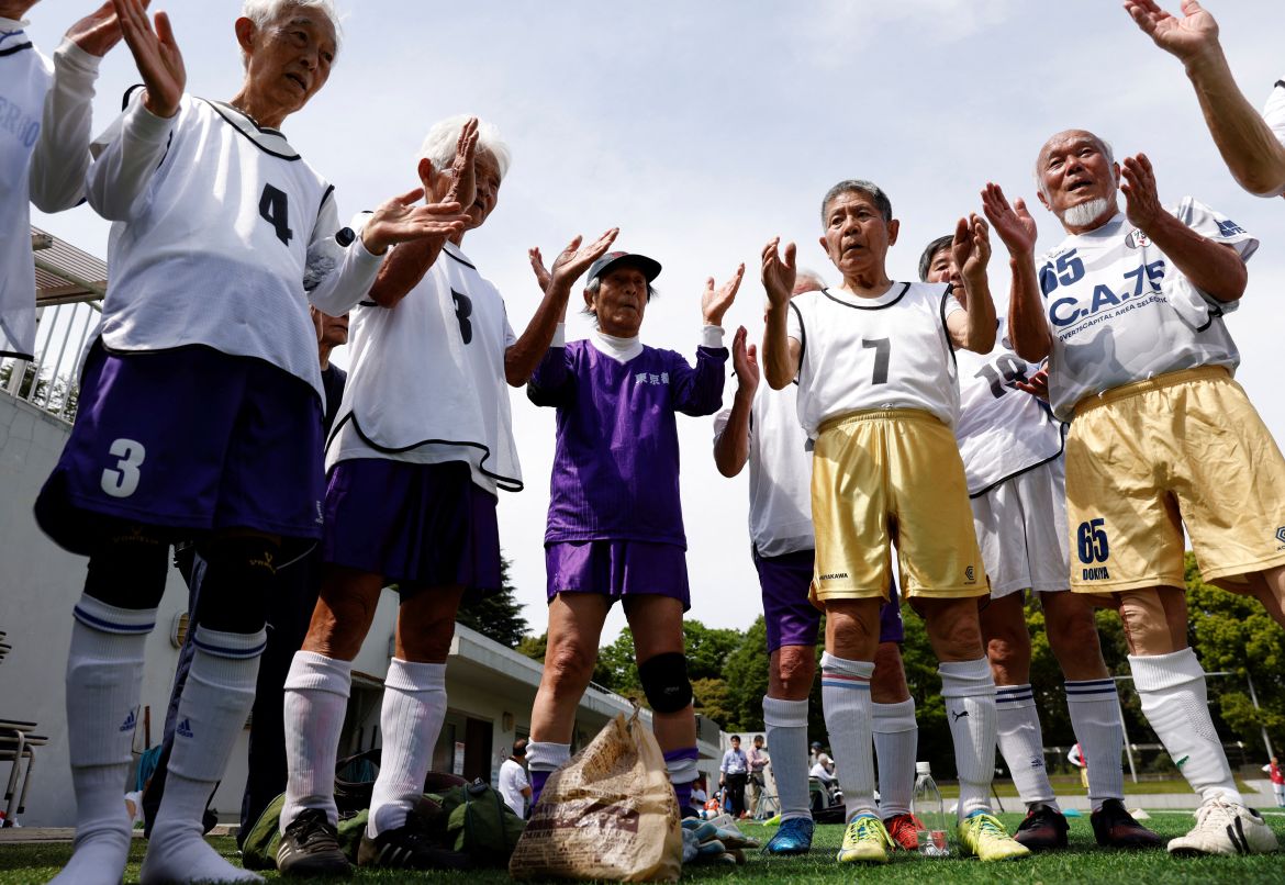 White Bear’s goalkeeper Shingo Shiozawa (center), 93, claps with his teammates following the Japanese custom 'temije' (a ceremonial rhythmic hand clapping), after the SFL (Soccer For Life) 80 League opening match