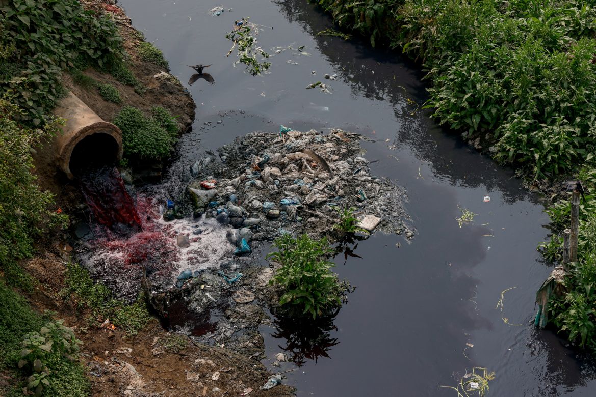 Water, which has been coloured by textile dye and will eventually flow through the Labandha, Turag and Buriganga rivers, is released near a paddy field in the Mawna Union area,