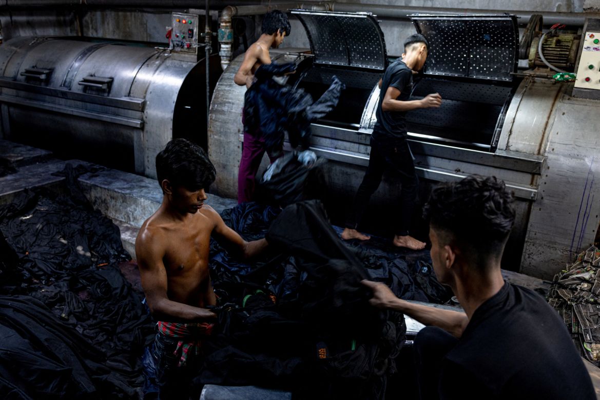 Factory workers wash and dry jeans in Dhaka