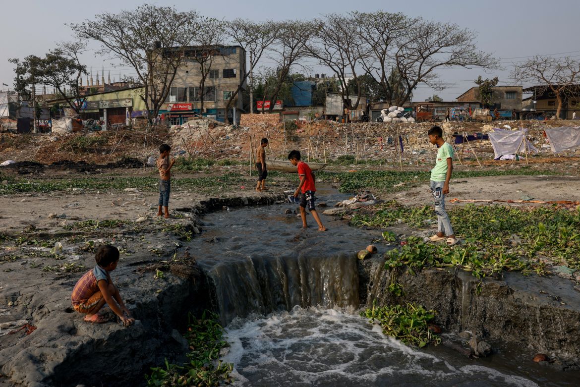 Children roam around an area where sewage water is directly discharged into the Buriganga river in Dhaka
