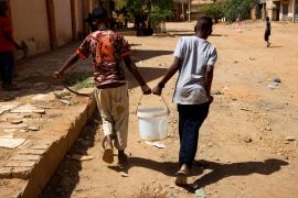 Two young people carrying water.