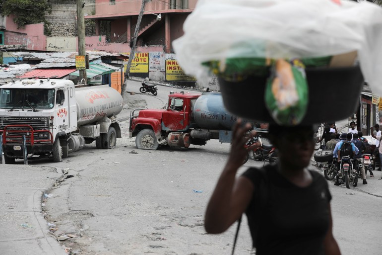 Trucks block the street as residents protest against gangs in Port-au-Prince