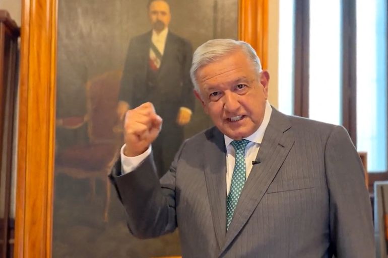 The Mexican President pumps his first in front of a painted portrait