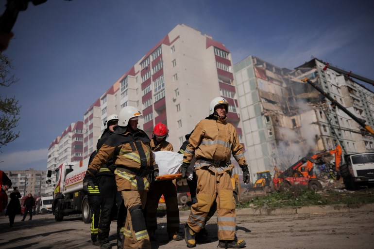 Rescuers carry a body covered with a bag as they work at the site of a heavily damaged residential building hit by a Russian missile, amid Russia's attack on Ukraine, in the town of Uman, Cherkasy region, Ukraine April 28, 2023. REUTERS/Carlos Barria