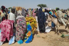Sudanese refugees who fled the violence in their country, gather for food given by the World Food Programme (WFP) near the border between Sudan and Chad, in Koufroun, Chad.