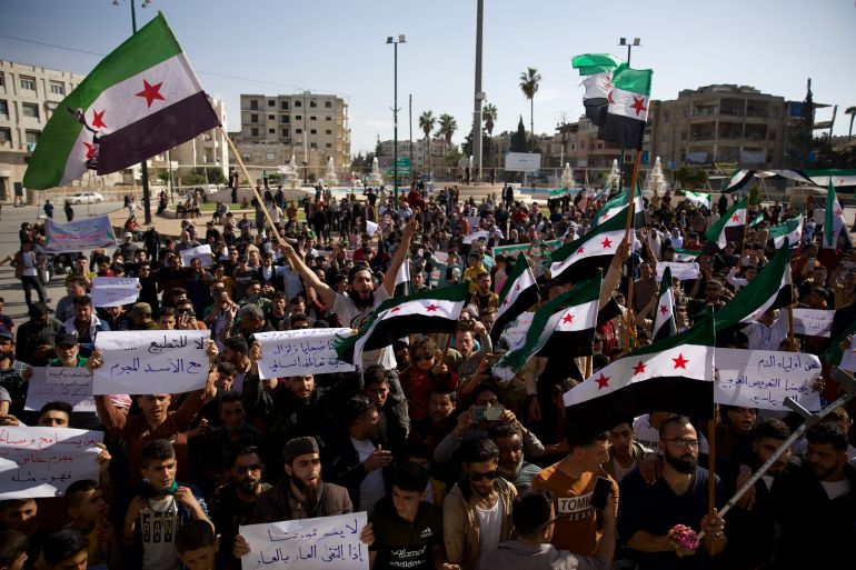 Some demonstrators held signs, including one that read: "Whoever forgives and reconciles (with Assad) is a criminal traitor... and islike him."