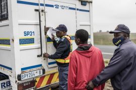 A migrant worker is detained by South Africa Police Services