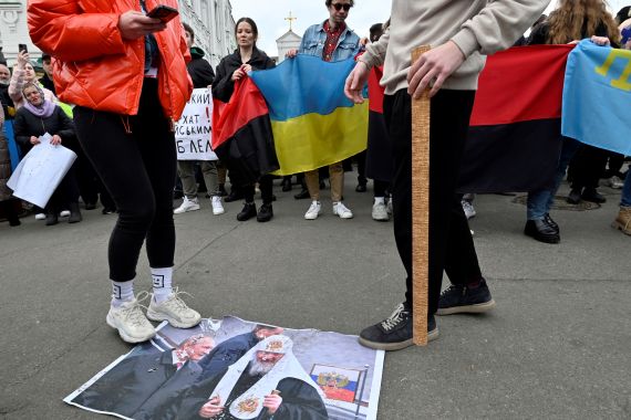 Pro-Ukrainian activists trample a photo of Russian President Vladimir Putin and Patriarch of Moscow and All Russia Kirill