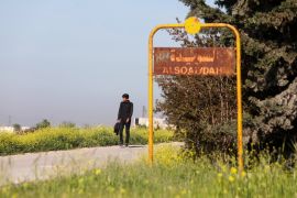 A man walks past the sign of Soueida near Jarablus, in the north-east of Syria's Aleppo province, on April 17, 2023,