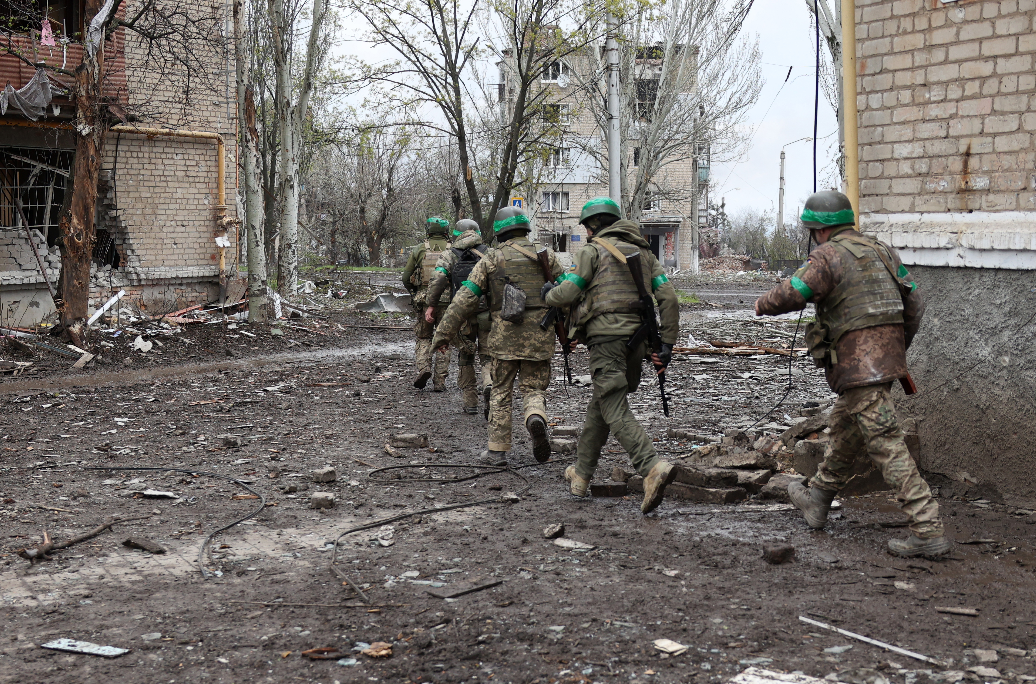 Ukrainian servicemen walk between residential buildings damaged by shelling in the frontline city of Bakhmut