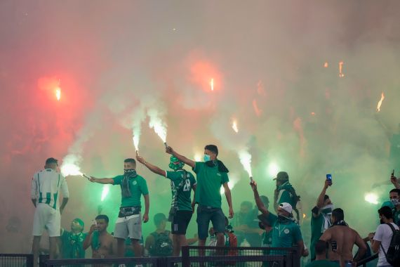 Raja Casablanca supporters burn flares during a friendly match between Roma and Raja Casablanca