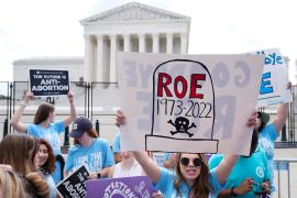 Anti-abortion rights groups hold up signs against abortion in front of the Supreme Court