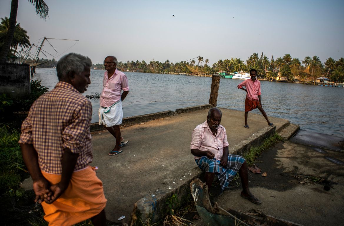 Elderly men idle away an evening by the backwaters in Kochi
