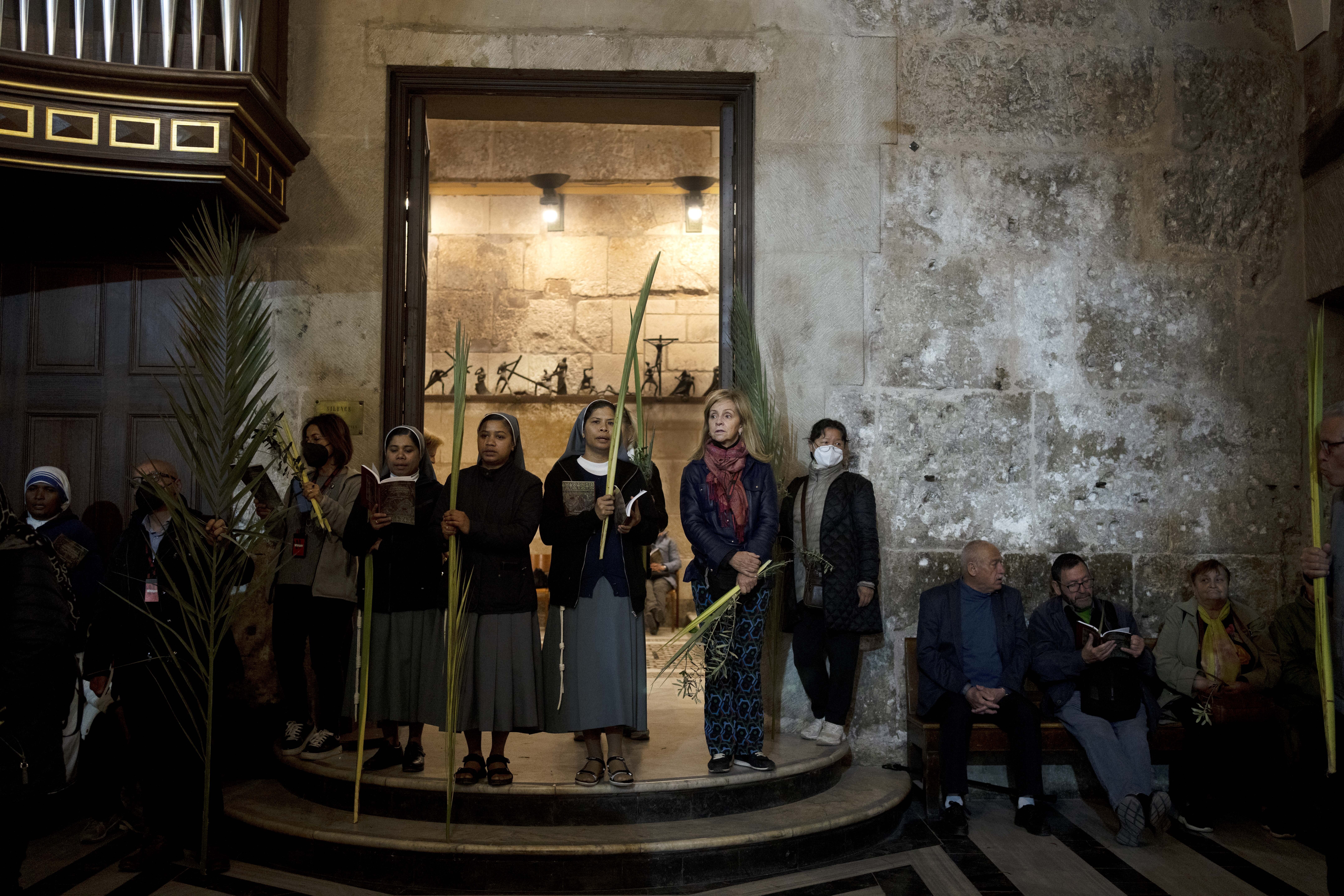 Christians take part in Palm Sunday Mass in the Church of the Holy Sepulchre
