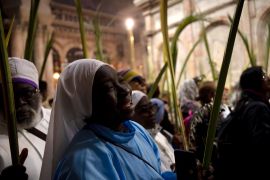 A nun sings while walking in a procession during Palm Sunday Mass