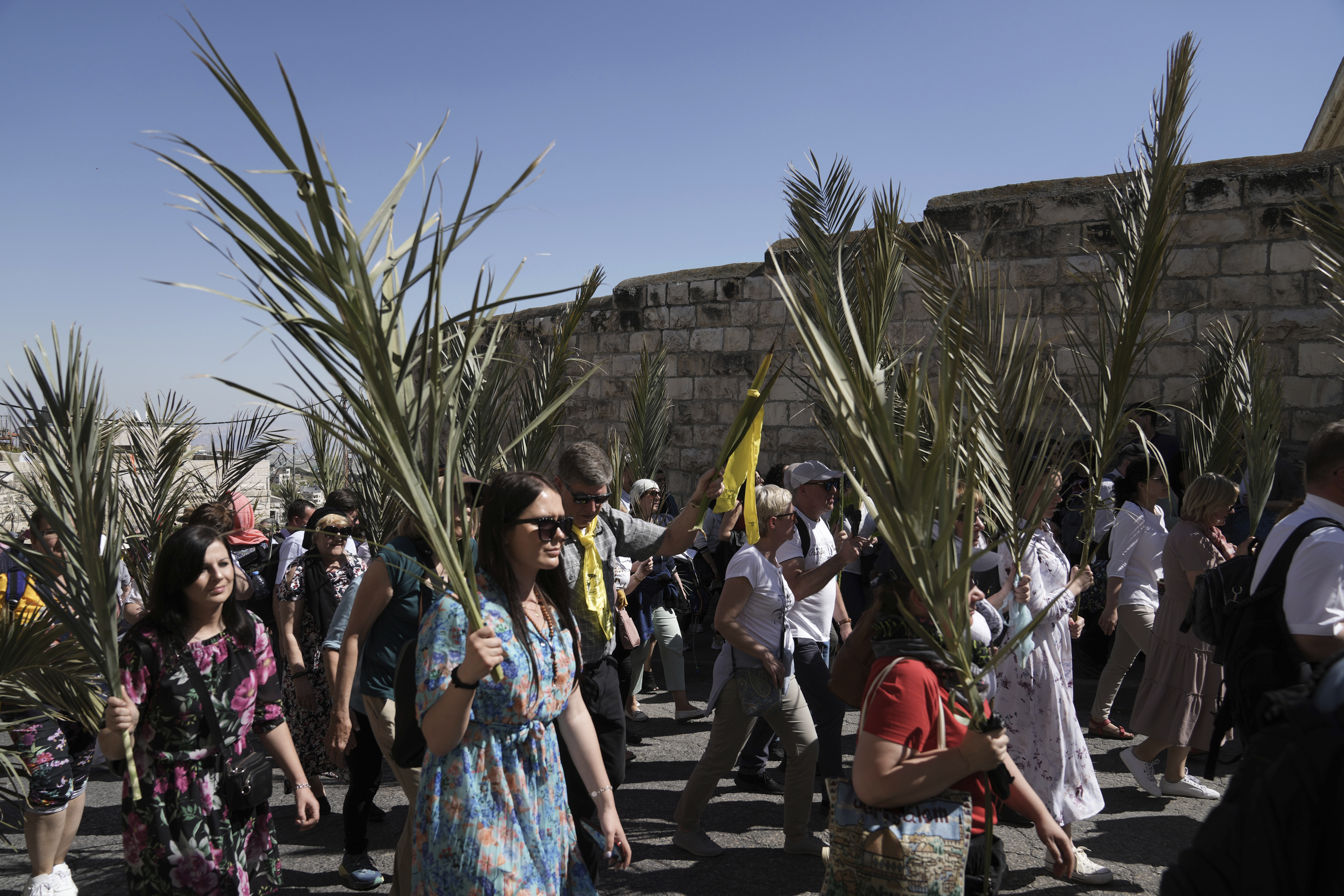 Nuns carry palm fronds as Christians walk in the Palm Sunday procession
