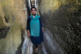 Sheela Singh, 39, stands in a narrow lane outside her house in a shanty area in Mumbai