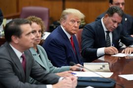Former President Donald Trump sits at the defense table with his defense team in a Manhattan court