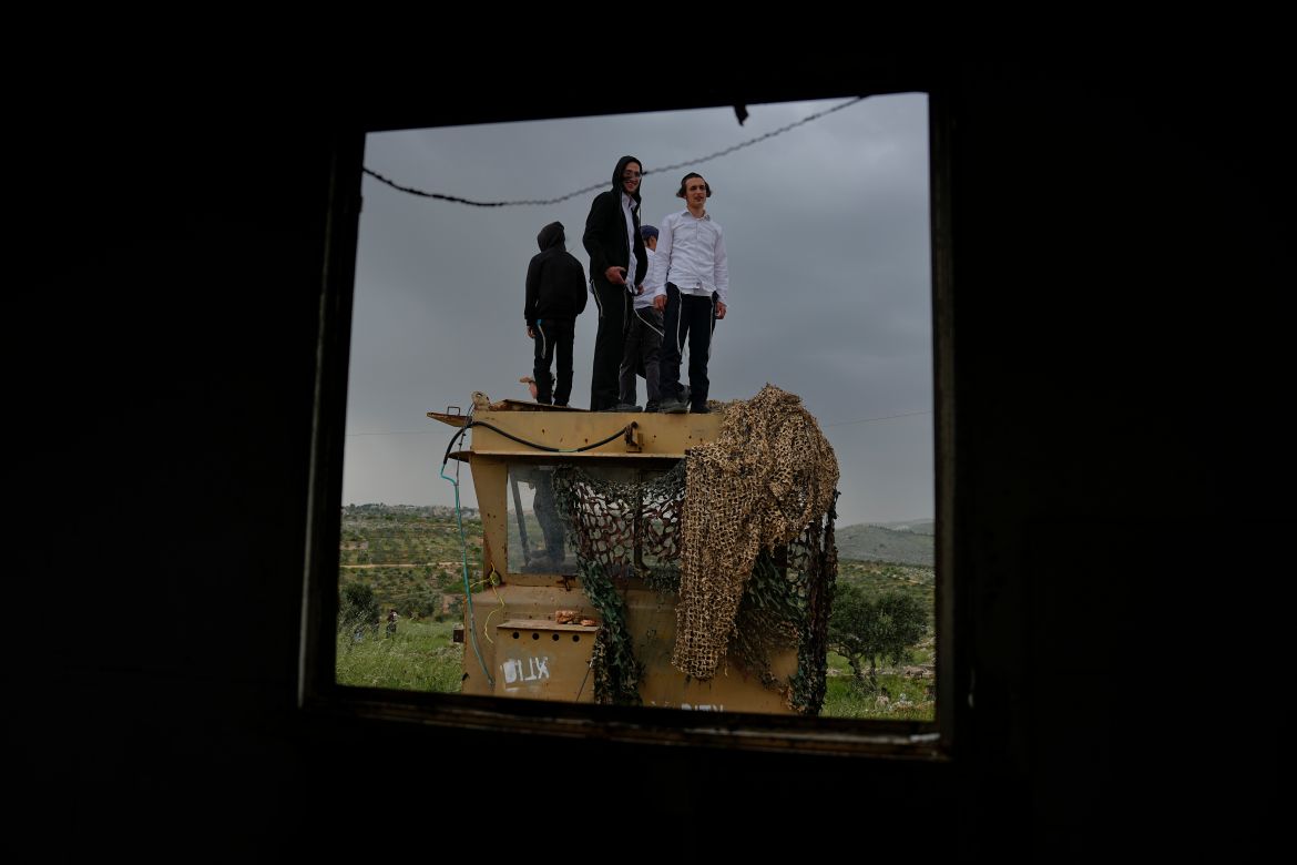 Israeli settlers stand in the outpost of Eviatar