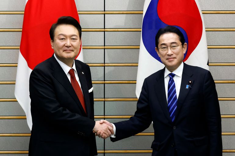 South Korean President Yoon Suk-yeol and Japanese Prime Minister Fumio Kishida shake hands ahead of their bilateral meeting at the prime minister's office in Tokyo, March 16, 2023.