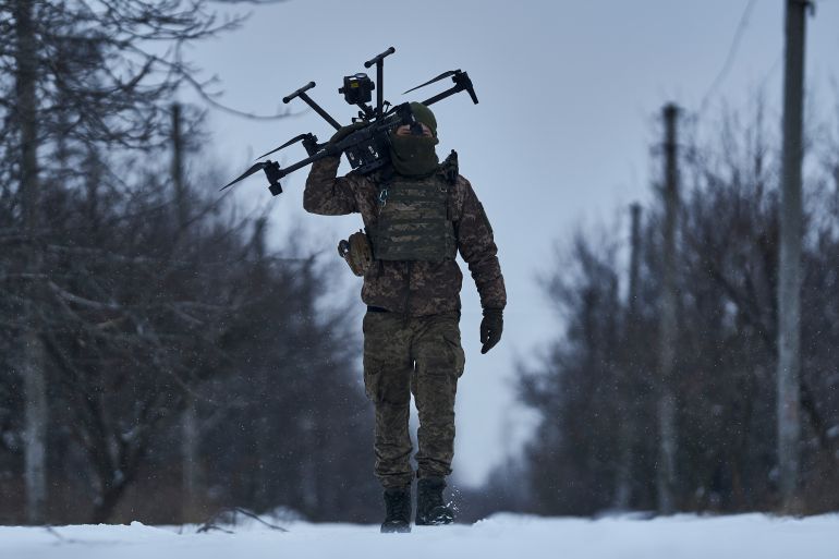 A Ukrainian soldier carries a drone close to the frontline near Avdiivka, Donetsk region, Ukraine, Friday, Feb. 17, 2023. Ukrainian government is launching a new initiative meant to streamline and promote innovation on drones and other technologies that have become critical in the country's fight against Russia, by bringing together state, military, and private sector developers working on defense issues. [Libkos/AP]