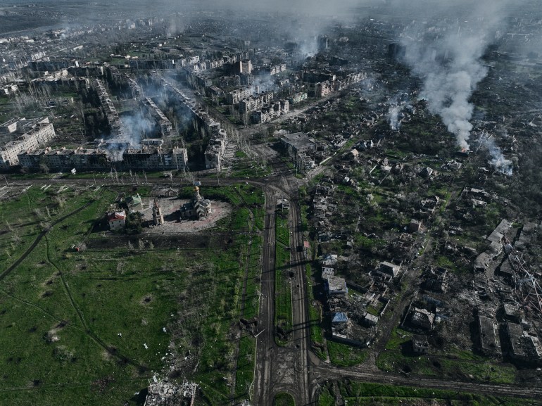 An aerial view of Bakhmut with smoke rising from the battlefield