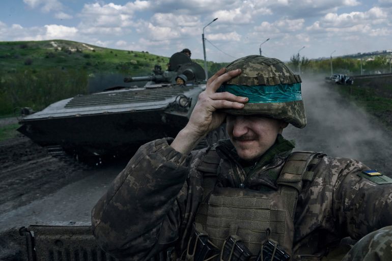 A Ukrainian soldier holds his helmet as he rides an APC in Bakhmut, in the Donetsk region, Ukraine.
