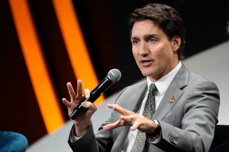Justin Trudeau holds a microphone and speaks on a panel in New York