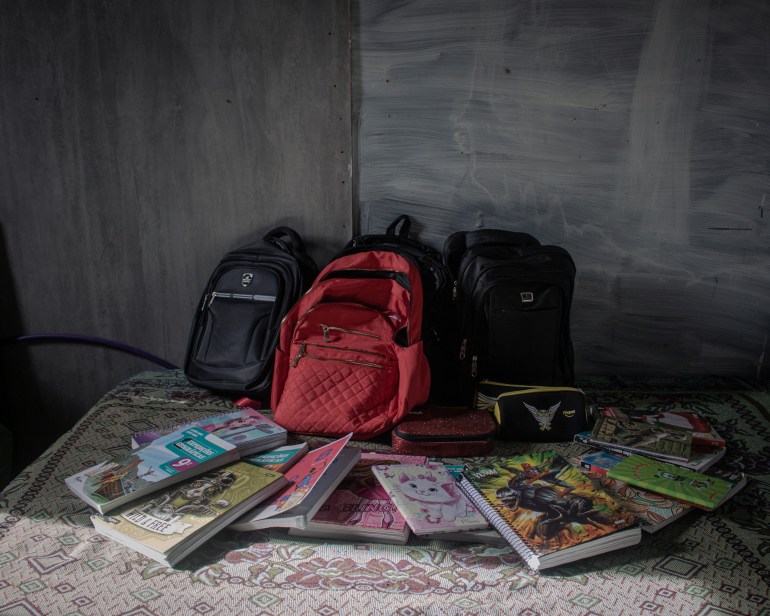 A photo of three backpacks with notebooks in front of them.