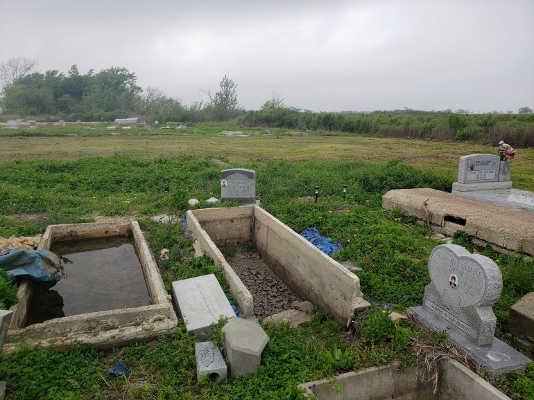 A photo of flooded graves in a graveyard.