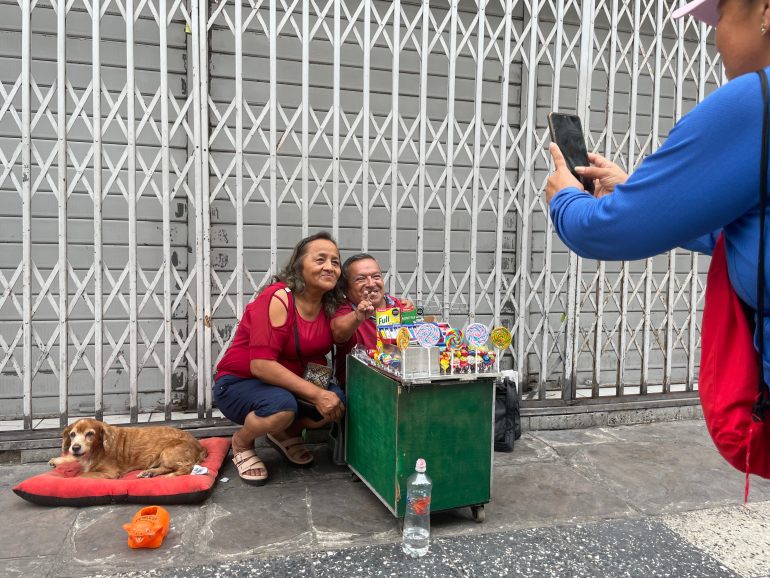 A street vendor in Peru takes a photo with a passerby