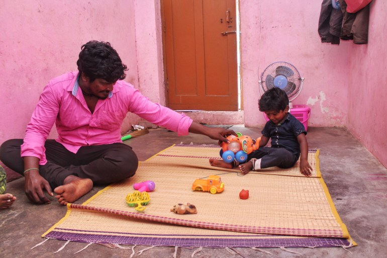 A photo of a man (left) playing with his child (right).