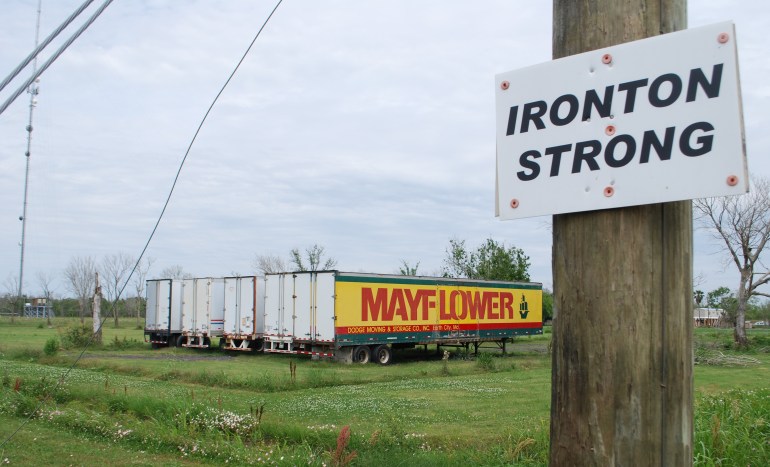 A photo of four long trucks with the word "Mayflower" on the one in the far right.