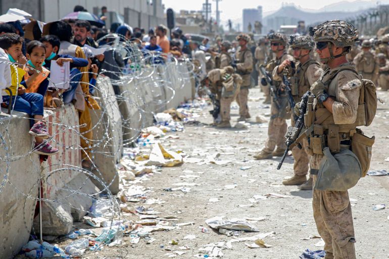 A line of soldiers survey a crowd of Afghans during the evacuations at the Kabul airport in Afghanistan.