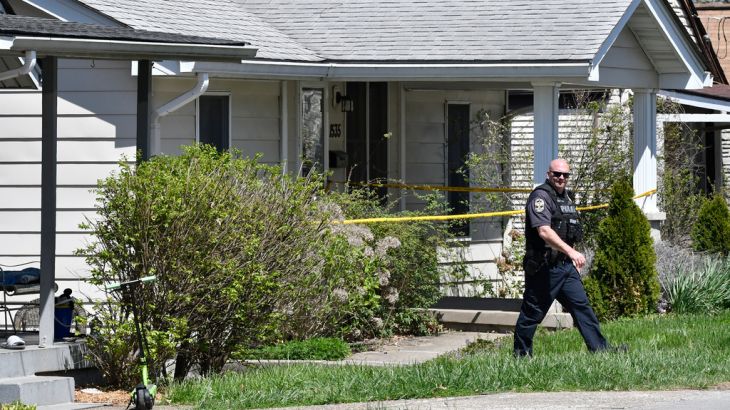 A police officer walks outside of the home of the man who carried out the attack on Monday