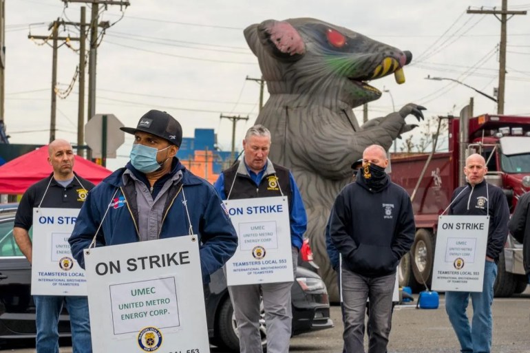 A photo of Andre Soleyn and colleagues on strike, holding banners with the words "On strike UMEC United Metro Energy Corp"