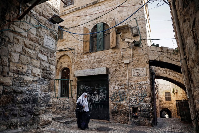 A Palestinian woman walks past a house in the Muslim Quarter of the Old City of Jerusalem