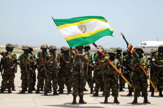 Ugandan soldiers, part of the African Union peacekeepers for Somalia, hold the flag of African Union at Mogadishu's international airport