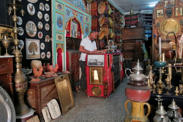 Aroussi Obay, 42, stands inside his souvenir shop in El Jem
