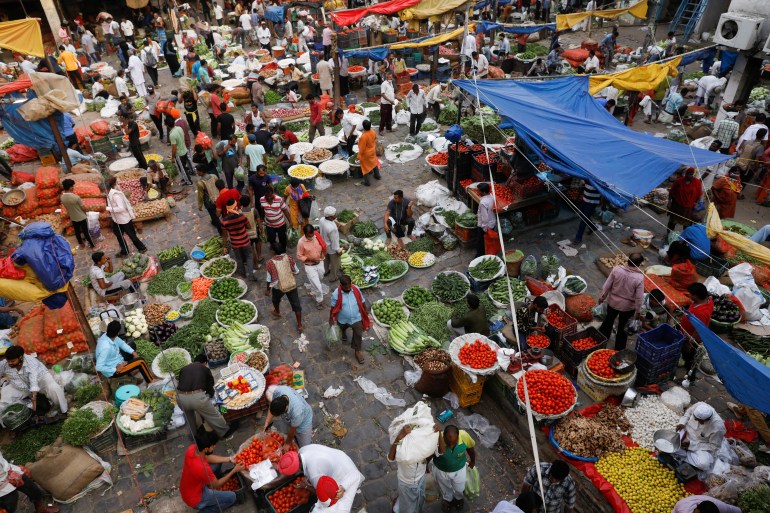 People shop at a vegetable market in Delhi